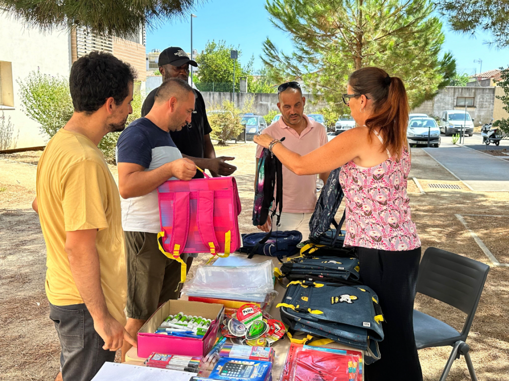Une femme donne des sacs à dos aux hommes